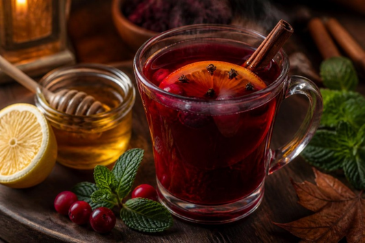 ruby red harvest berry toddy with orange slice, cinnamon and honey